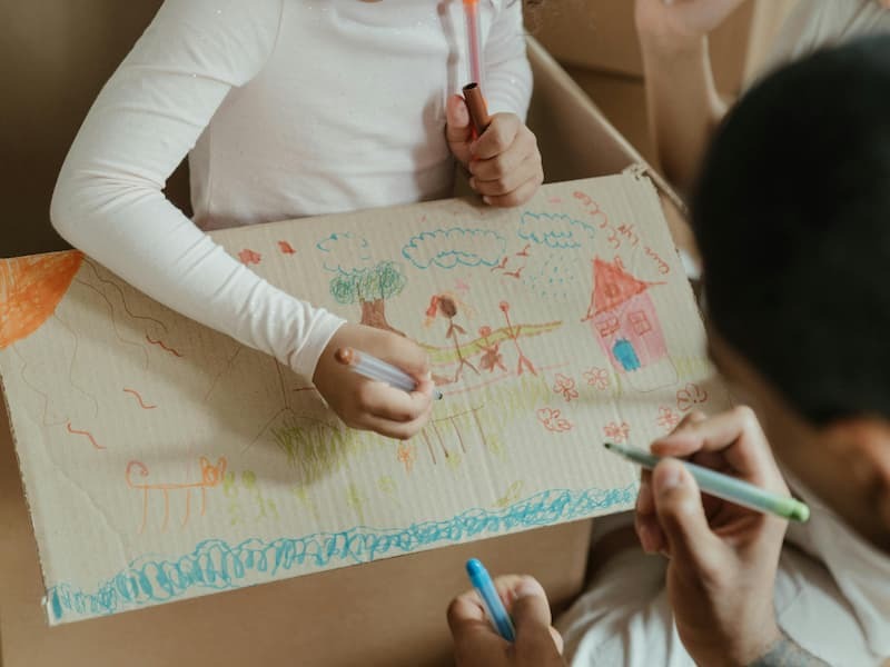 Moving with Kids. Photo by cottonbro studio from Pexels: https://www.pexels.com/photo/brown-cardboard-box-on-brown-wooden-table-4569863/