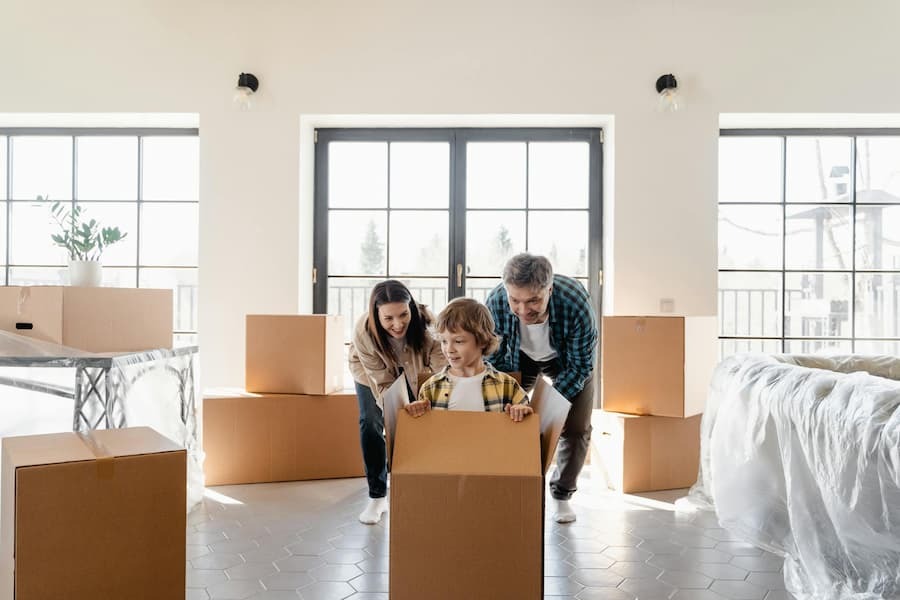 Moving with Kids. Photo by MART  PRODUCTION from Pexels: https://www.pexels.com/photo/a-couple-looking-at-their-son-inside-the-box-7415039/